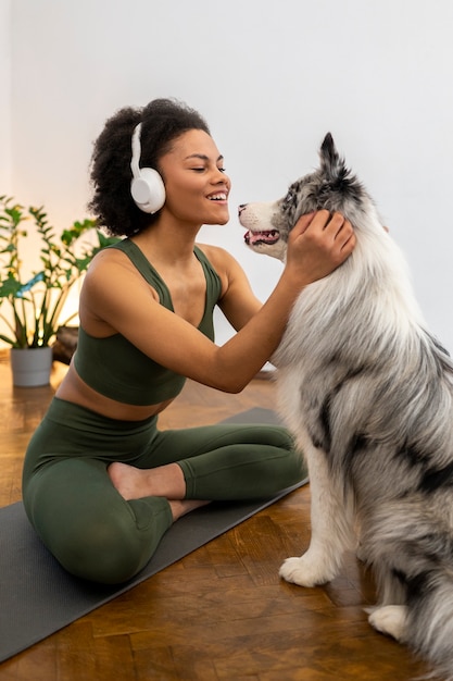 Foto gratuita persona que hace yoga acompañada de su mascota