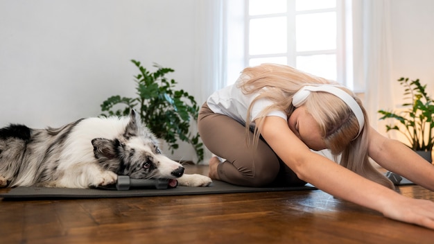 Foto gratuita persona que hace yoga acompañada de su mascota