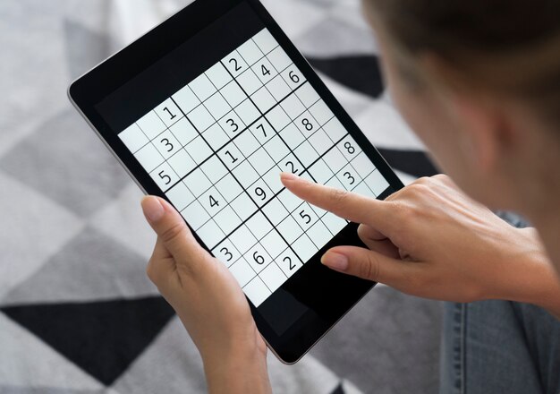 Persona que juega un juego de sudoku en una tableta