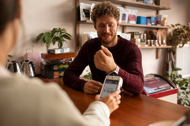 Persona que paga la cuenta en un restaurante usando tecnología nfc