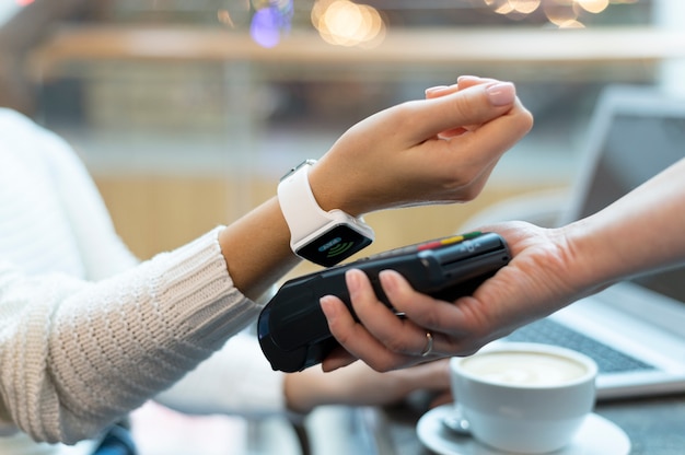 Foto gratuita persona que paga con su aplicación de billetera smartwatch