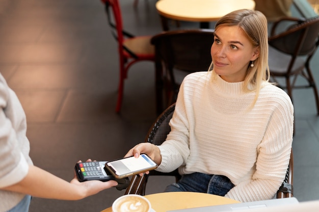 Persona que paga con su aplicación de billetera para teléfono inteligente