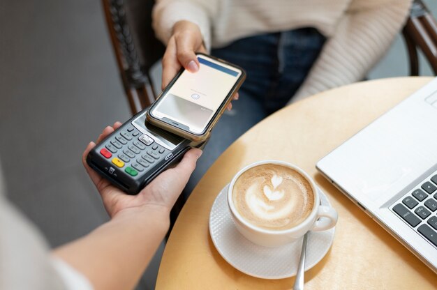 Persona que paga con su aplicación de billetera para teléfono inteligente