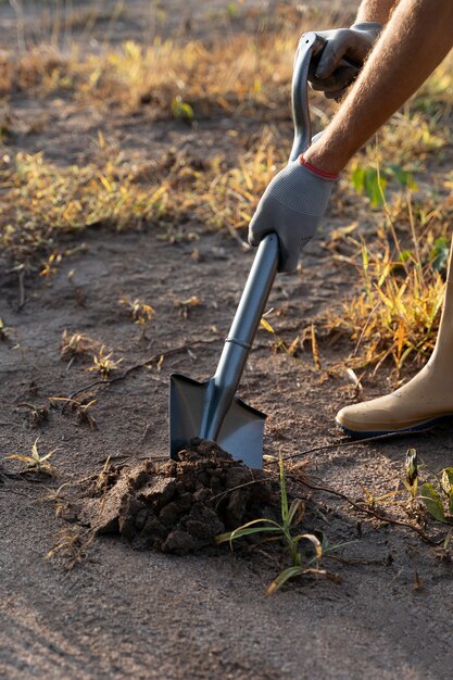 Persona que planta un árbol en el campo.