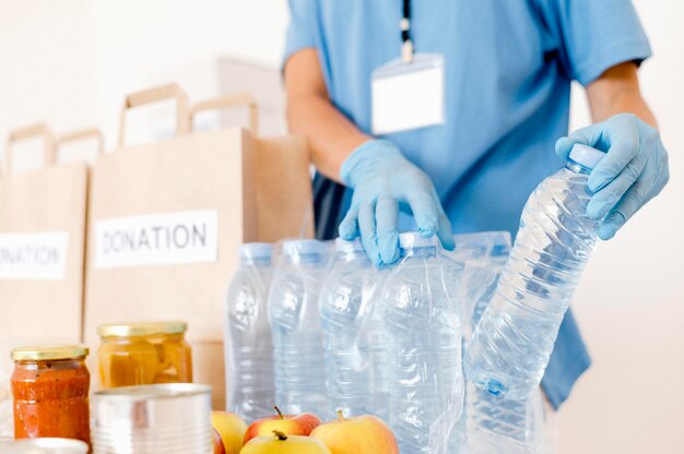 Persona que pone botellas de agua en bolsas de donación