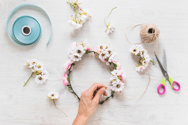 Una persona que prepara la corona de flores sobre el telón de fondo con textura