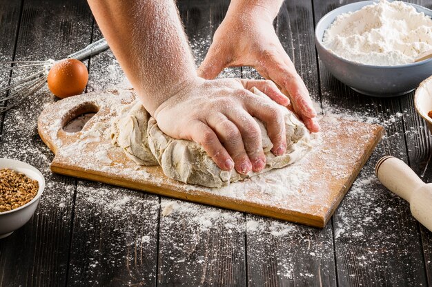 Una persona que prepara la masa de pan en la tabla de cortar