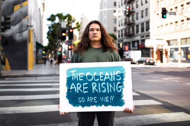 Persona que protesta con carteles para el día mundial del medio ambiente al aire libre