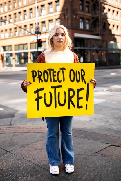 Persona que protesta con carteles para el día mundial del medio ambiente al aire libre