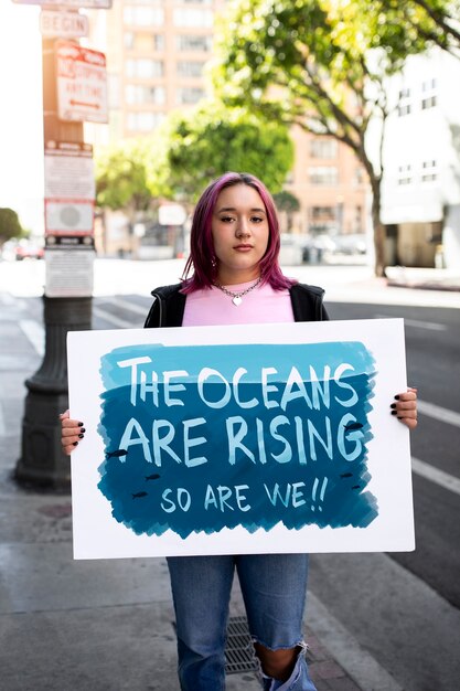 Persona que protesta con carteles para el día mundial del medio ambiente al aire libre