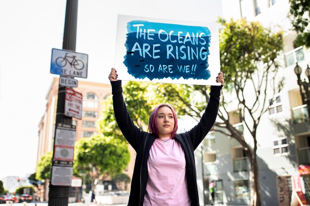 Persona que protesta con carteles para el día mundial del medio ambiente al aire libre