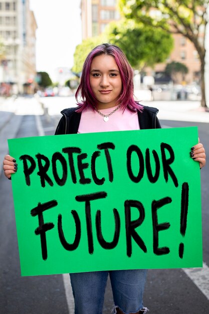 Persona que protesta con carteles para el día mundial del medio ambiente al aire libre