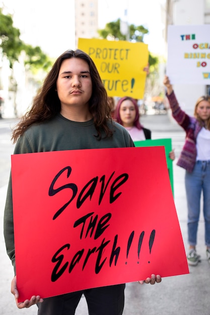 Persona que protesta con carteles para el día mundial del medio ambiente al aire libre