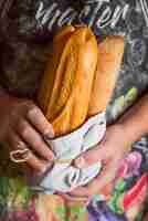 Foto gratuita persona que sostiene baguettes francesas vista frontal