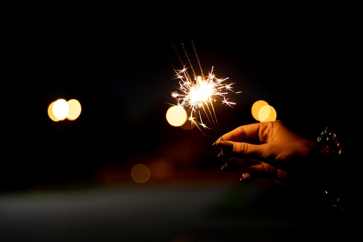 Foto gratuito persona que sostiene una chispa festiva