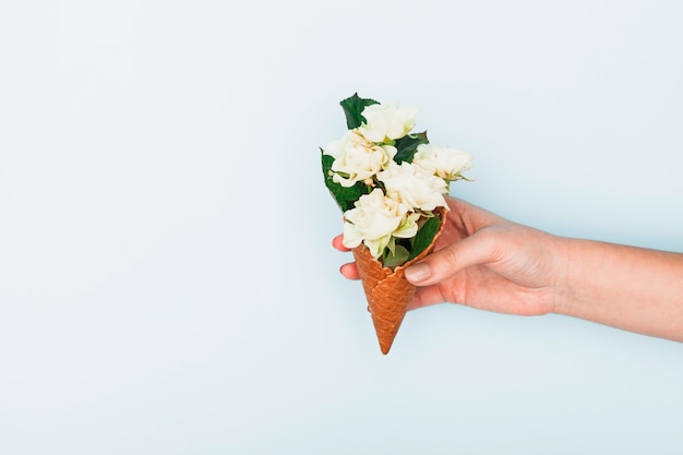 Persona que sostiene el cono de galleta con rosas