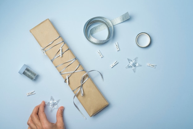 Persona que sostiene la estrella en la mesa con caja de regalo