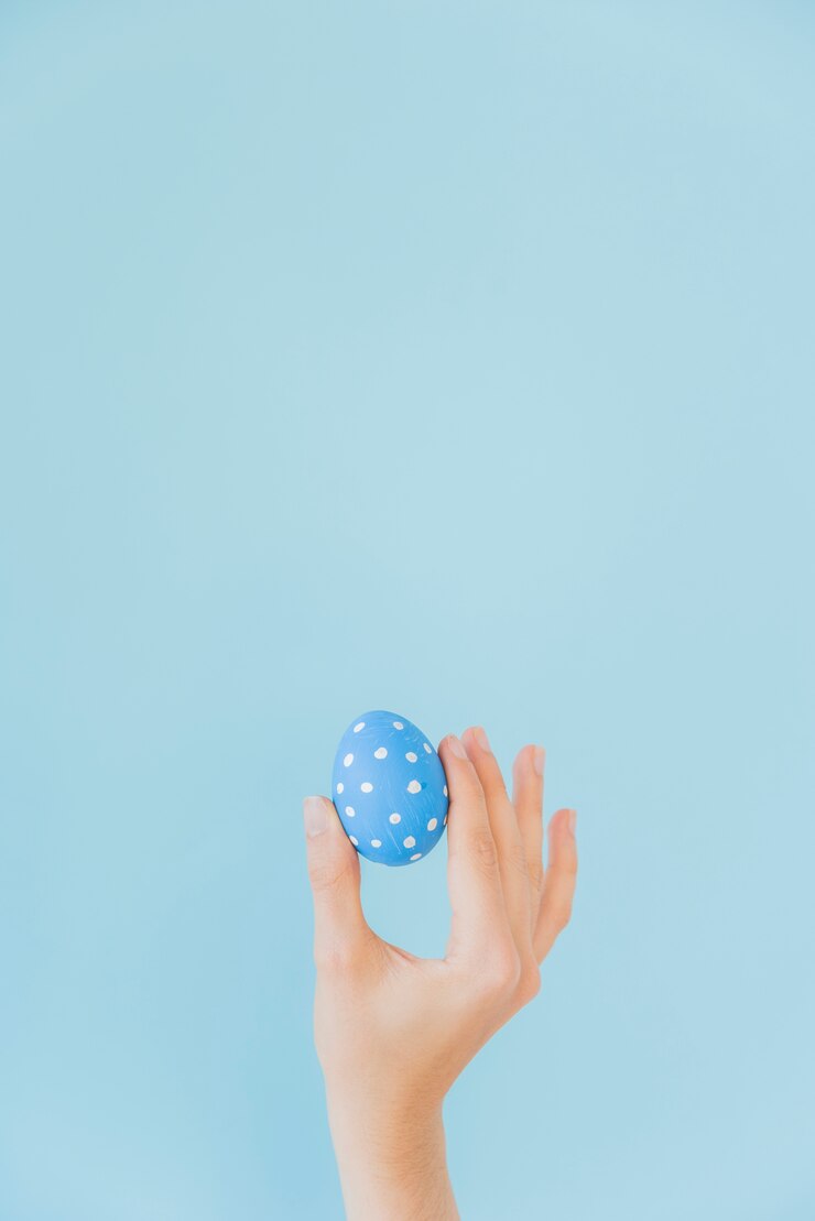 Foto gratuito persona que sostiene el huevo de pascua azul en la mano