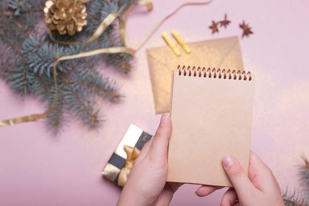 Foto gratuita persona que sostiene la libreta encima de la mesa de navidad