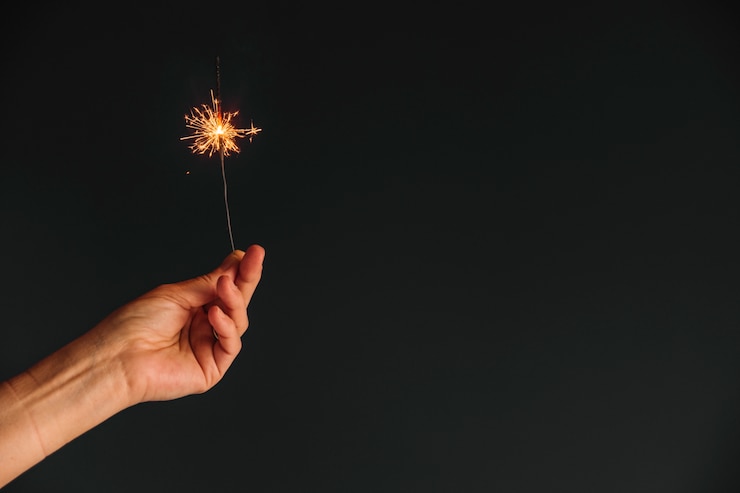 Foto gratuito persona que tiene la luz de bengala en la mano