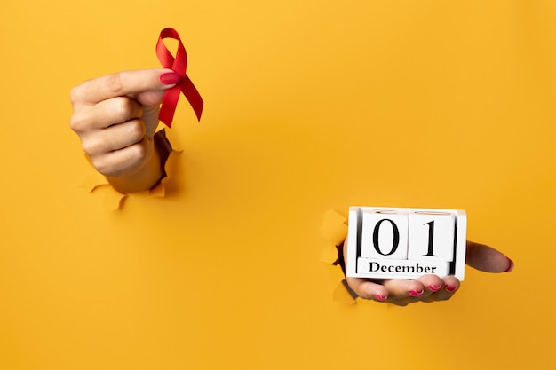 Persona que tiene un símbolo de cinta del día mundial del sida con la fecha del evento