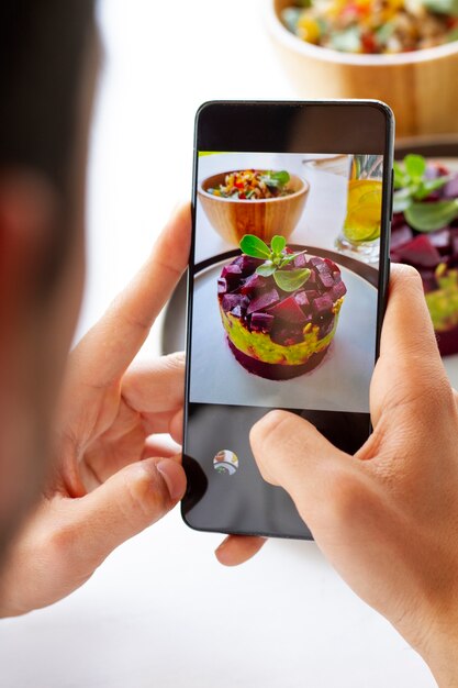 Persona que toma la foto del postre de frutas con teléfono inteligente