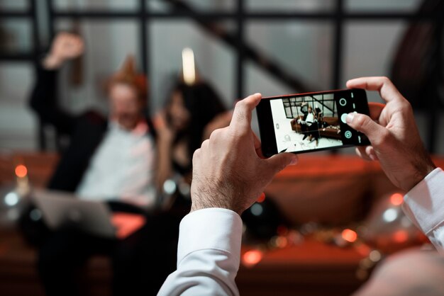 Persona que toma una foto de sus amigos en la fiesta de fin de año