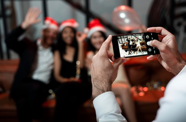 Persona que toma una foto de sus mejores amigos en la fiesta de fin de año