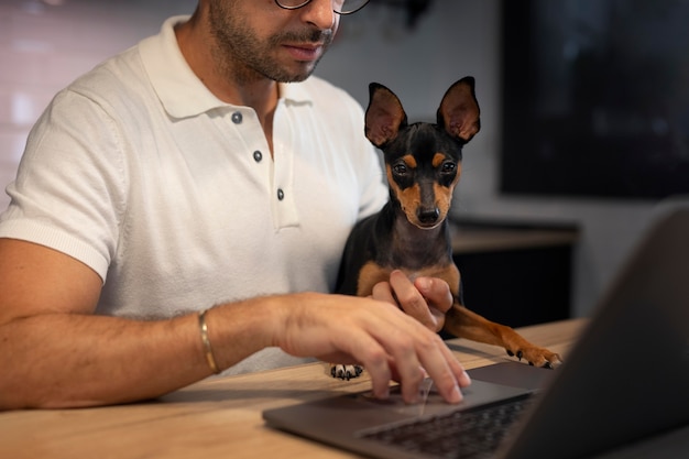 Foto gratuita persona que trabaja desde casa con perro mascota