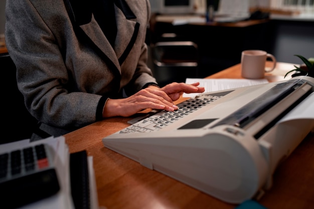 Foto gratuita persona que trabaja en un escritorio en una oficina de estilo vintage de los años 90