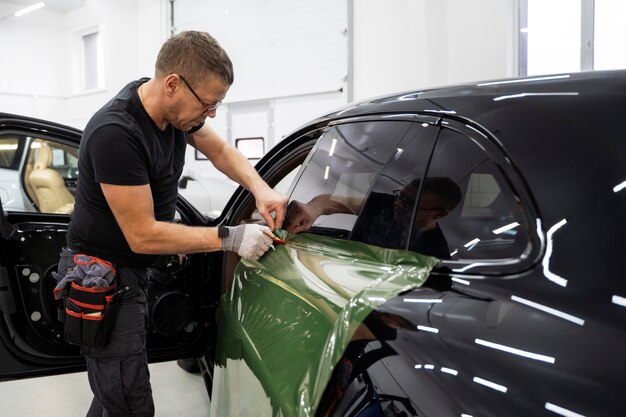 Persona que trabaja en la rotulación de automóviles.