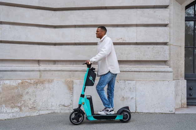 Foto gratuita persona que usa scooter eléctrico en la ciudad