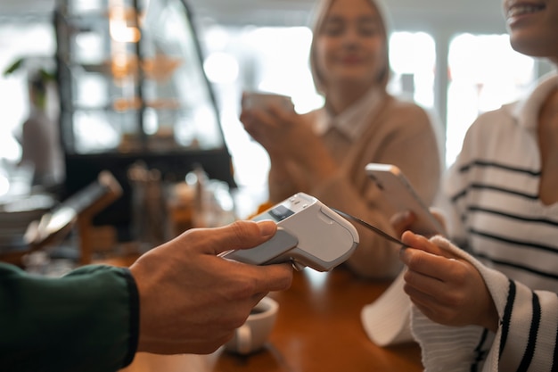 Foto gratuita persona que usa tecnología nfc para pagar en un restaurante