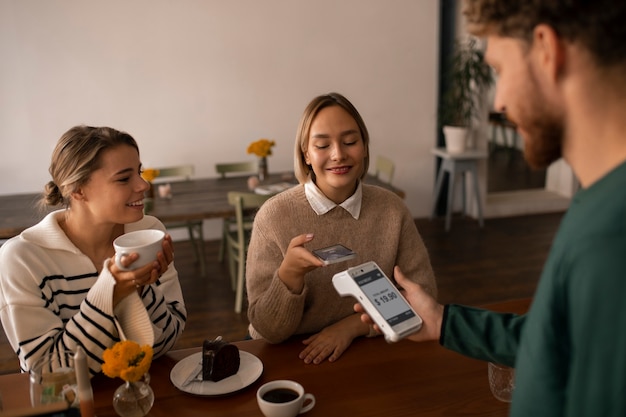 Foto gratuita persona que usa tecnología nfc para pagar en un restaurante