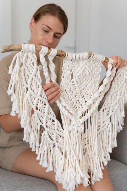 Persona que utiliza la técnica de macramé en interiores