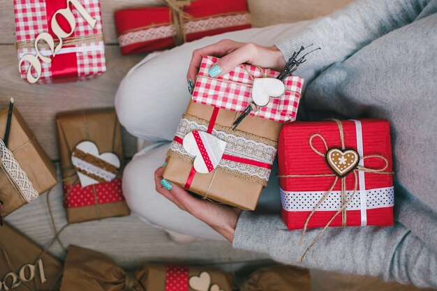 Persona sentada de rodillas con varios regalos de san valentin