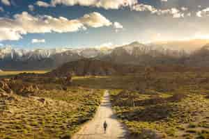 Foto gratuita persona solitaria caminando por un sendero en las colinas de alabama en california con mount whitney