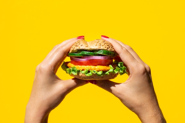 Persona sosteniendo una deliciosa hamburguesa vegetariana