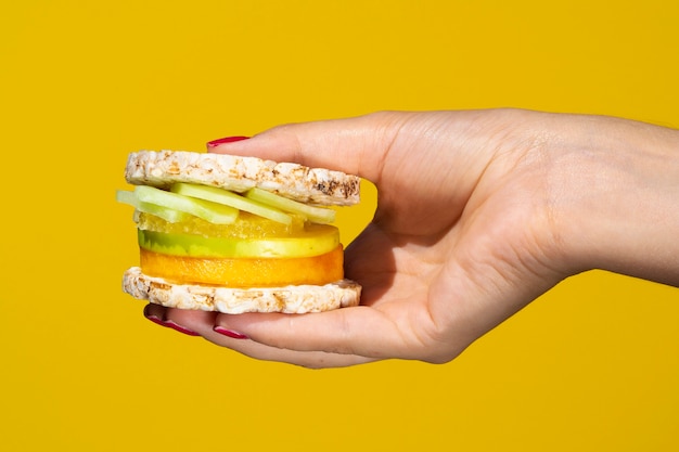 Foto gratuita persona sosteniendo un exótico sandwich con frutas