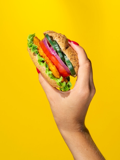 Persona sosteniendo una jugosa hamburguesa vegetariana