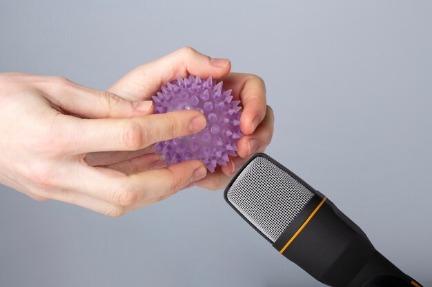 Persona sosteniendo una pelota de goma cerca del micrófono para asmr