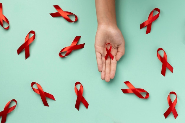 Persona sosteniendo un símbolo de cinta del día mundial del sida