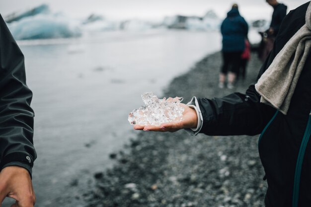 Persona sostiene un trozo de hielo glaciar en islandia