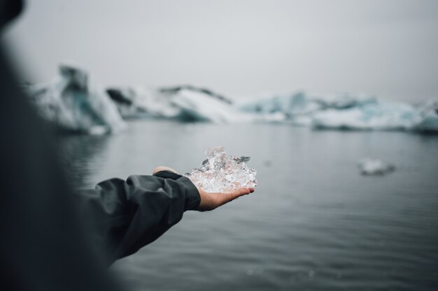 Persona sostiene un trozo de hielo glaciar en islandia