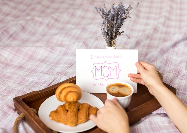 Foto gratuita persona con tarjeta de felicitación y taza de café en bandeja