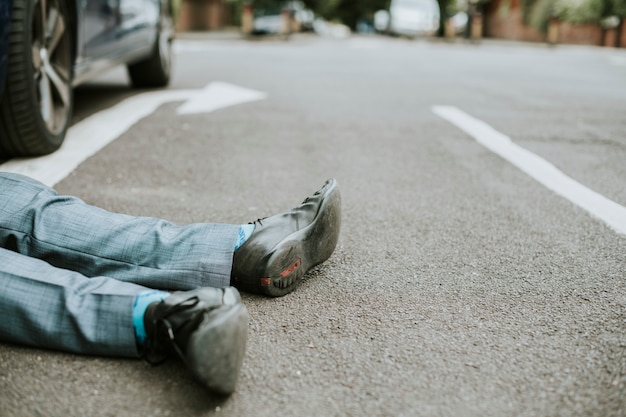 Foto gratuita persona tendida en el suelo después de un accidente automovilístico