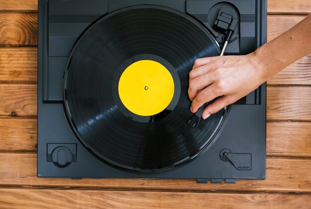 Persona tocando un disco de vinilo en un reproductor de música vintage