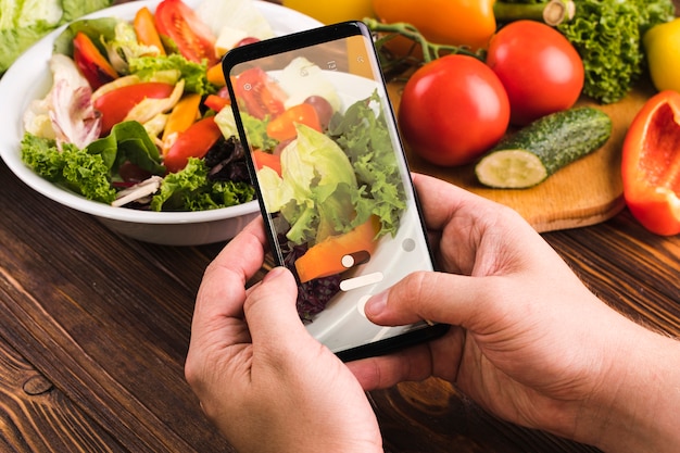 Foto gratuita persona tomando una foto de ensalada