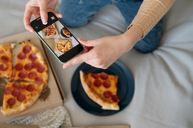 Foto gratuita persona tomando foto de pizza de pepperoni