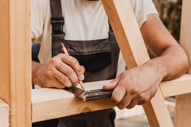 Persona tomando medidas sobre madera